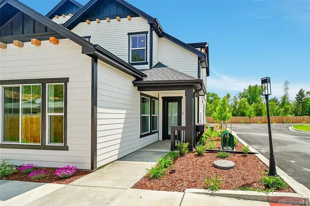 a view of a house with a yard and potted plants