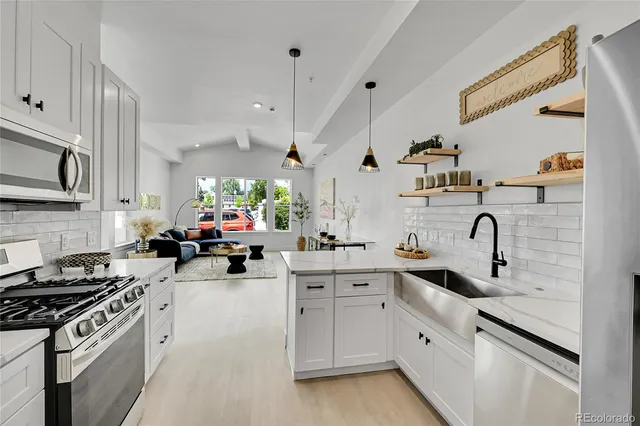a kitchen with white cabinets and appliances