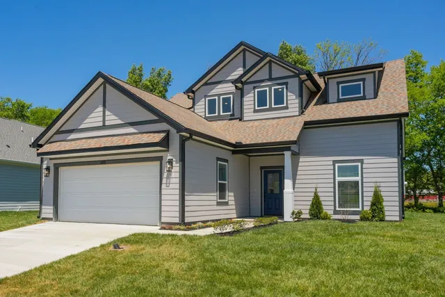 a front view of a house with a garden and yard