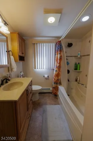 a bathroom with a tub sink toilet and window