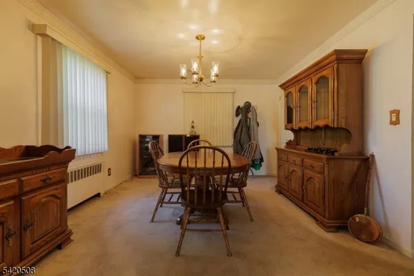 a view of a dining room with furniture and chandelier