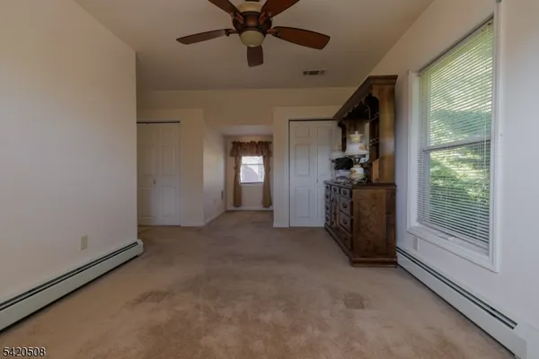 en empty room with windows and ceiling fan