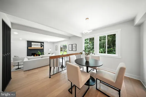 a living room with furniture a dining table and a large window