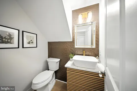 a bathroom with a toilet a sink and a mirror