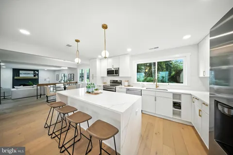 a kitchen with stainless steel appliances granite countertop sink stove top oven and cabinets