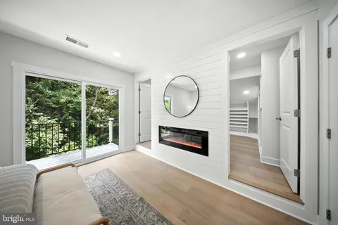 a view of a livingroom with wooden floor a fireplace and a window
