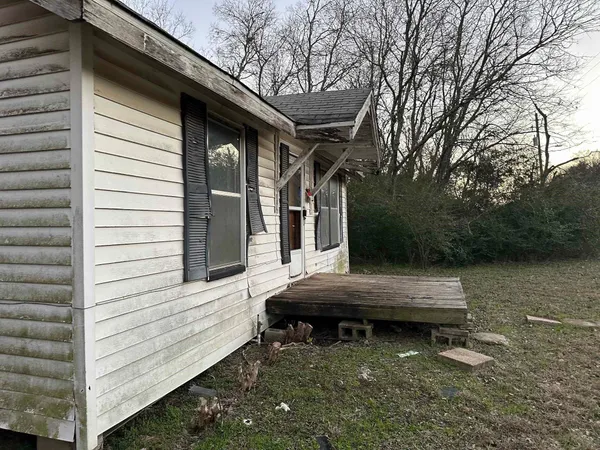 a view of house with backyard and outdoor seating