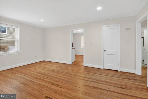 a view of empty room with wooden floor and windows