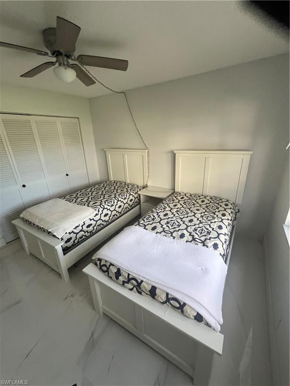 3 Bluebill Avenue, Unit 207 Naples, FL 34108 - Photo 13 of 27 Bedroom with a ceiling fan, marble finish flooring, and a closet