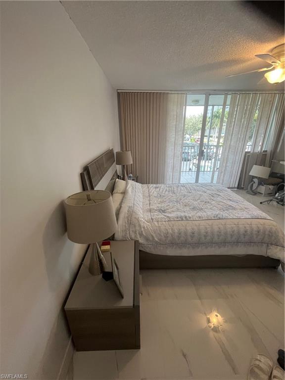 3 Bluebill Avenue, Unit 207 Naples, FL 34108 - Photo 16 of 27 Bedroom featuring a textured ceiling, access to outside, and a ceiling fan