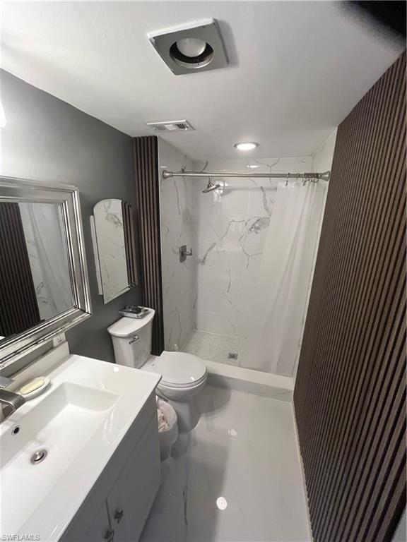 3 Bluebill Avenue, Unit 207 Naples, FL 34108 - Photo 17 of 27 Bathroom with vanity and a marble finish shower