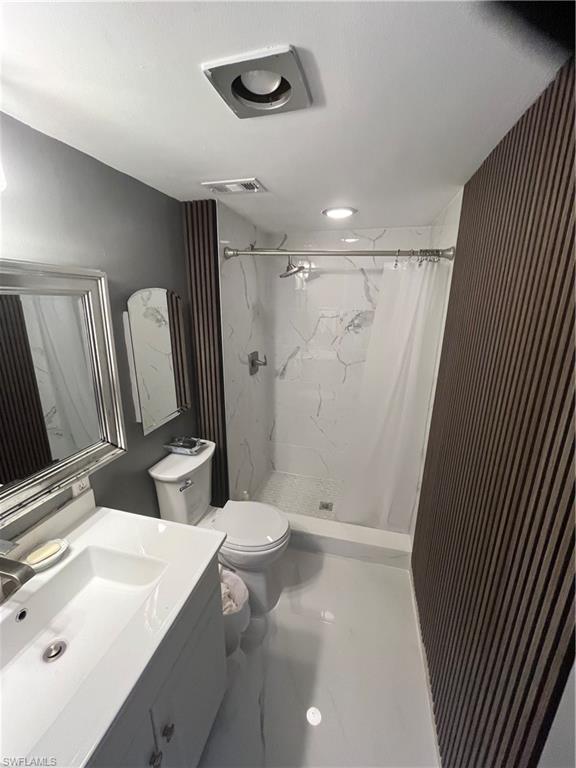 3 Bluebill Avenue, Unit 207 Naples, FL 34108 - Photo 19 of 27 Bathroom featuring vanity and a marble finish shower