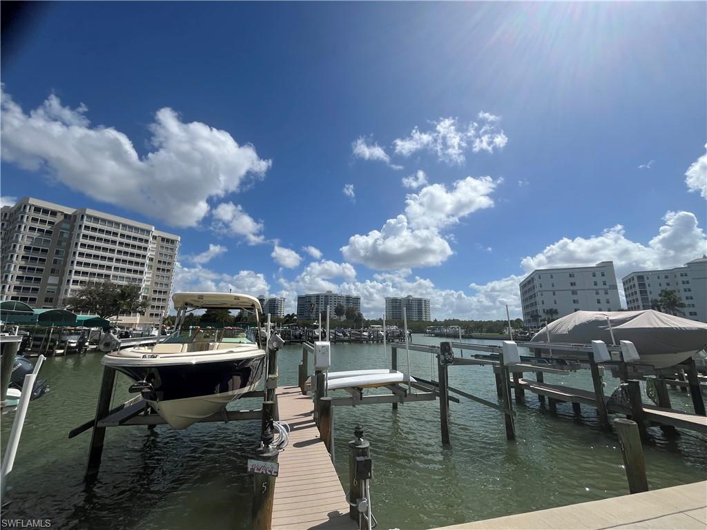 3 Bluebill Avenue, Unit 207 Naples, FL 34108 - Photo 2 of 27 Dock area featuring boat lift, a water view, and a view of city