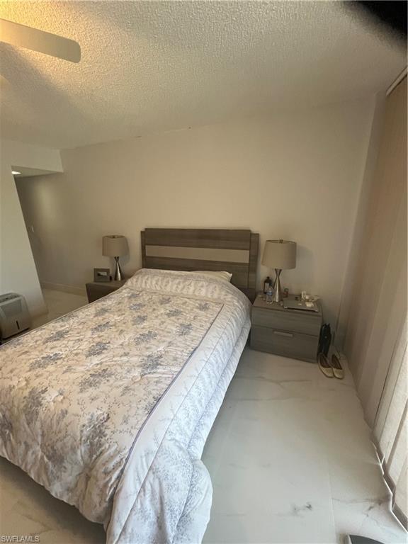 3 Bluebill Avenue, Unit 207 Naples, FL 34108 - Photo 21 of 27 Bedroom featuring a textured ceiling and ceiling fan