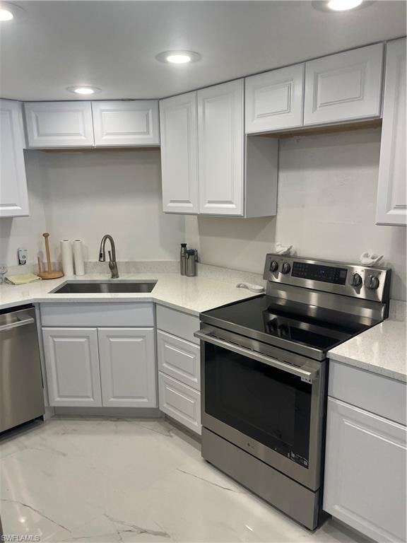 3 Bluebill Avenue, Unit 207 Naples, FL 34108 - Photo 26 of 27 Kitchen with stainless steel range, dishwashing machine, light stone counters, white cabinets, and recessed lighting