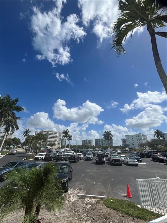 3 Bluebill Avenue, Unit 207 Naples, FL 34108 - Photo 4 of 27 Uncovered parking lot featuring a view of city