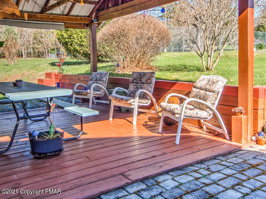 259 Babbling Brook Road Scotrun, PA 18355 - Photo 25 of 63 a view of a patio with table and chairs potted plants with wooden floor and fence