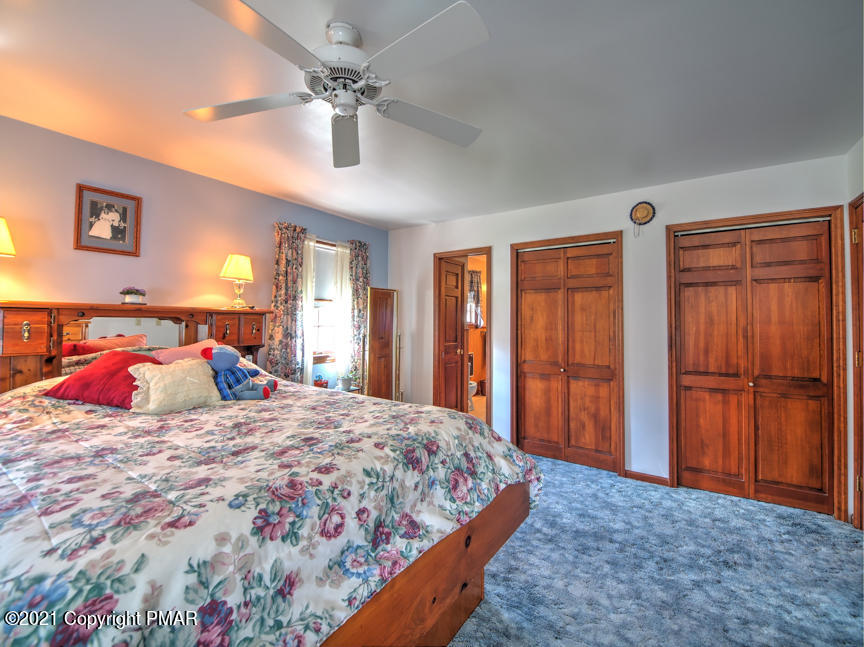 259 Babbling Brook Road Scotrun, PA 18355 - Photo 35 of 63 a bedroom with a large bed and a chandelier