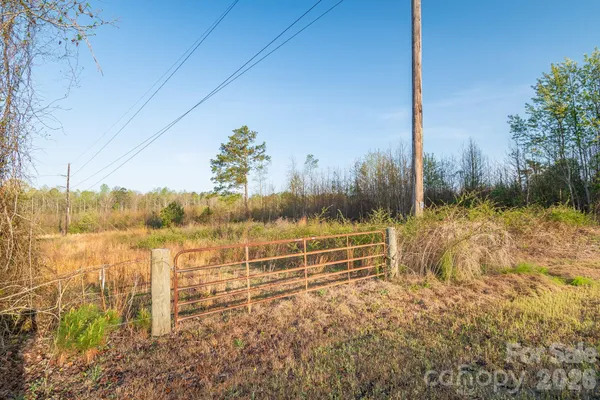 a view of a yard with wooden fence