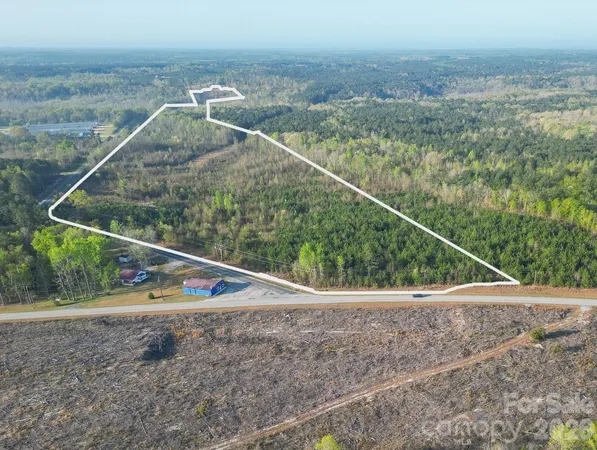 a view of a dry yard with wooden fence
