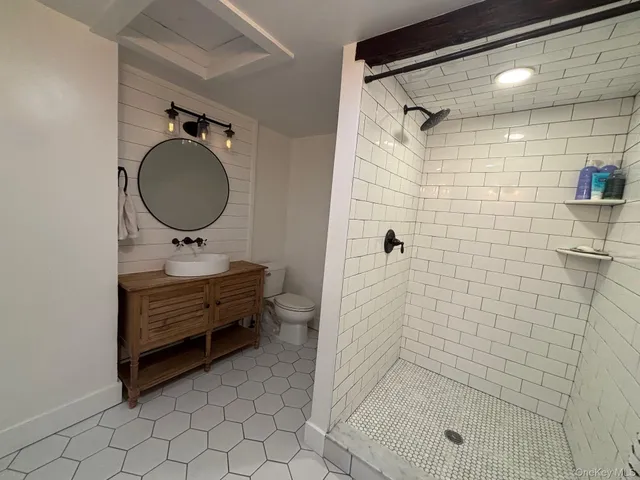 a bathroom with a sink mirror and shower