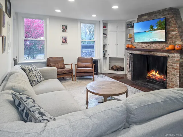a living room with furniture a flat screen tv and a fireplace