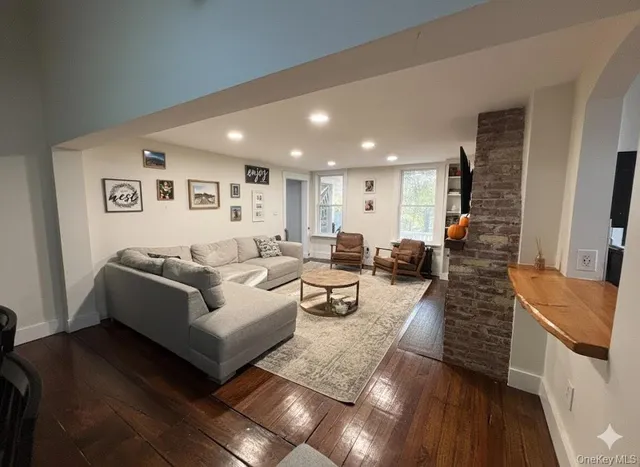 a living room with furniture and a view of kitchen