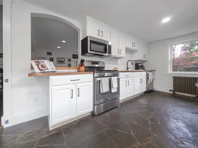 a kitchen with white cabinets stainless steel appliances and sink