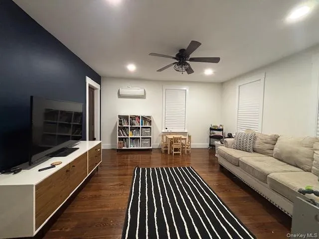a living room with furniture a flat screen tv and kitchen view