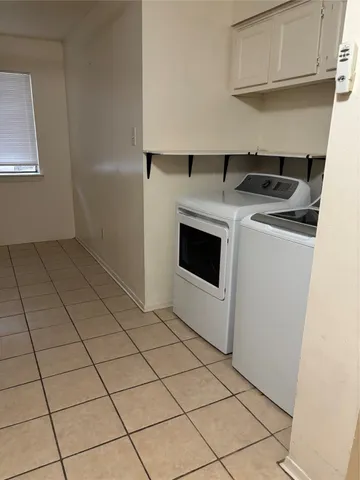 a kitchen with washing machine and cabinets