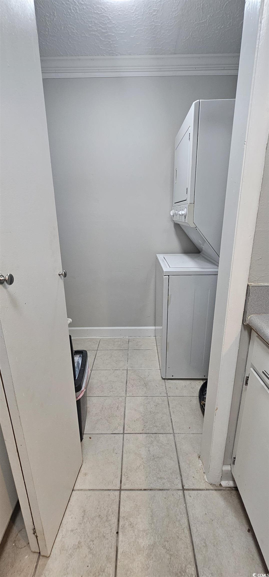 615 Carter Lane, Unit A1 Conway, SC 29526 - Photo 5 of 24 Washroom featuring a textured ceiling, crown molding, estacked washer and dryer, and light tile patterned flooring