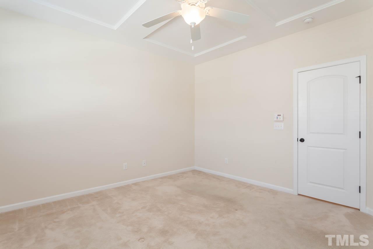 7326 Caversham Way Raleigh, NC 27617 - Photo 17 of 23 an empty room with a ceiling fan and carpet