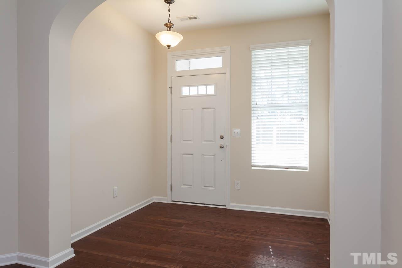 7326 Caversham Way Raleigh, NC 27617 - Photo 5 of 23 an empty room with wooden floor and windows