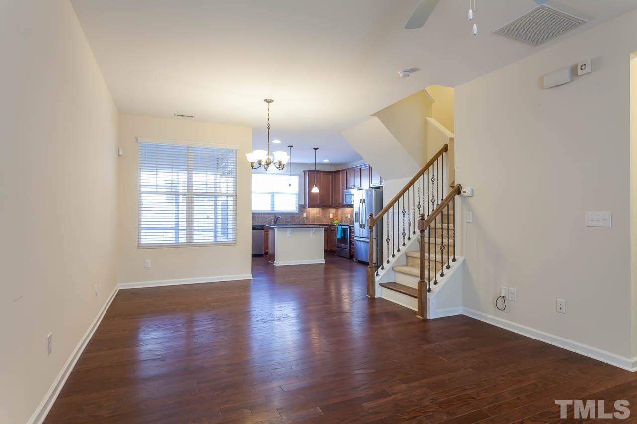 7326 Caversham Way Raleigh, NC 27617 - Photo 6 of 23 an empty room with wooden floor and outdoor view