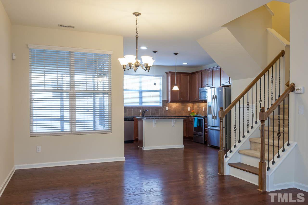 7326 Caversham Way Raleigh, NC 27617 - Photo 8 of 23 a open kitchen with stainless steel appliances granite countertop a refrigerator a sink dishwasher a stove and white countertops with wooden floor