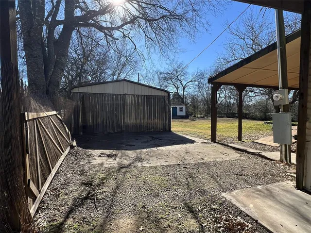 a view of a backyard with a small cabin and wooden fence