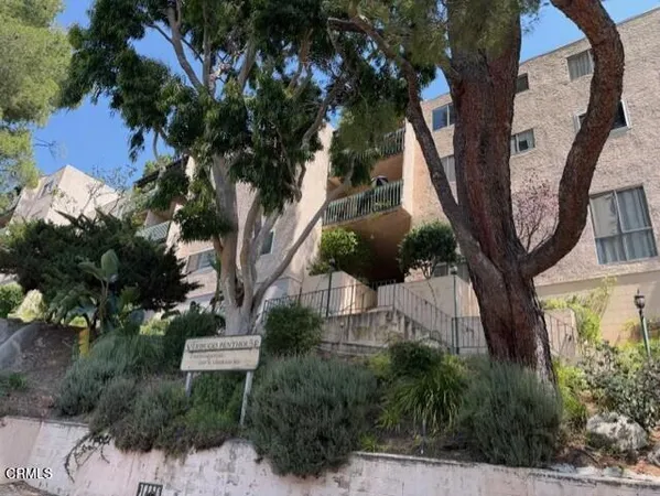 a view of a house with a tree in the background