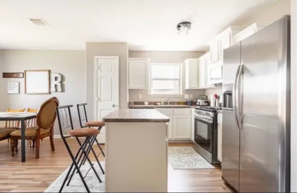 a kitchen with kitchen island a counter top space a sink appliances and cabinets