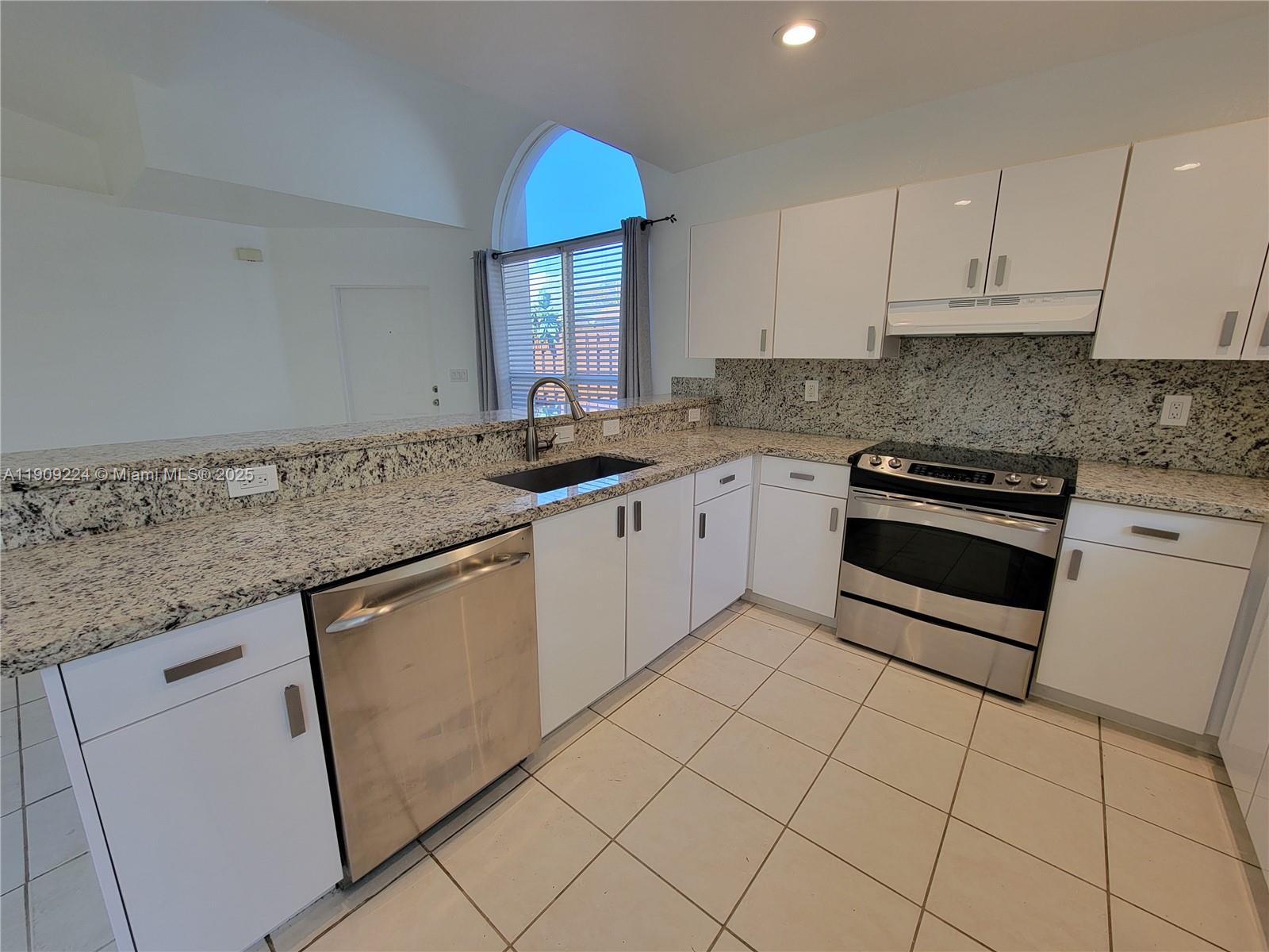 35 Southwest 7th Street, Unit 2 Hallandale Beach, FL 33009 - Photo 19 of 23 a kitchen with granite countertop a sink a stove and cabinets