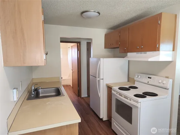 a kitchen with a stove a refrigerator and a sink