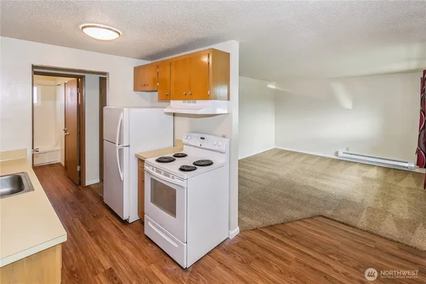a kitchen with a wooden floor and white appliances