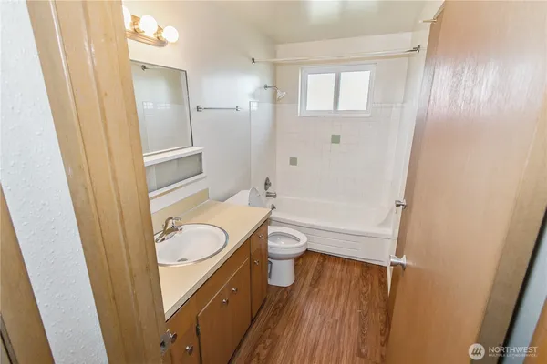 a bathroom with a granite countertop toilet a sink and a mirror