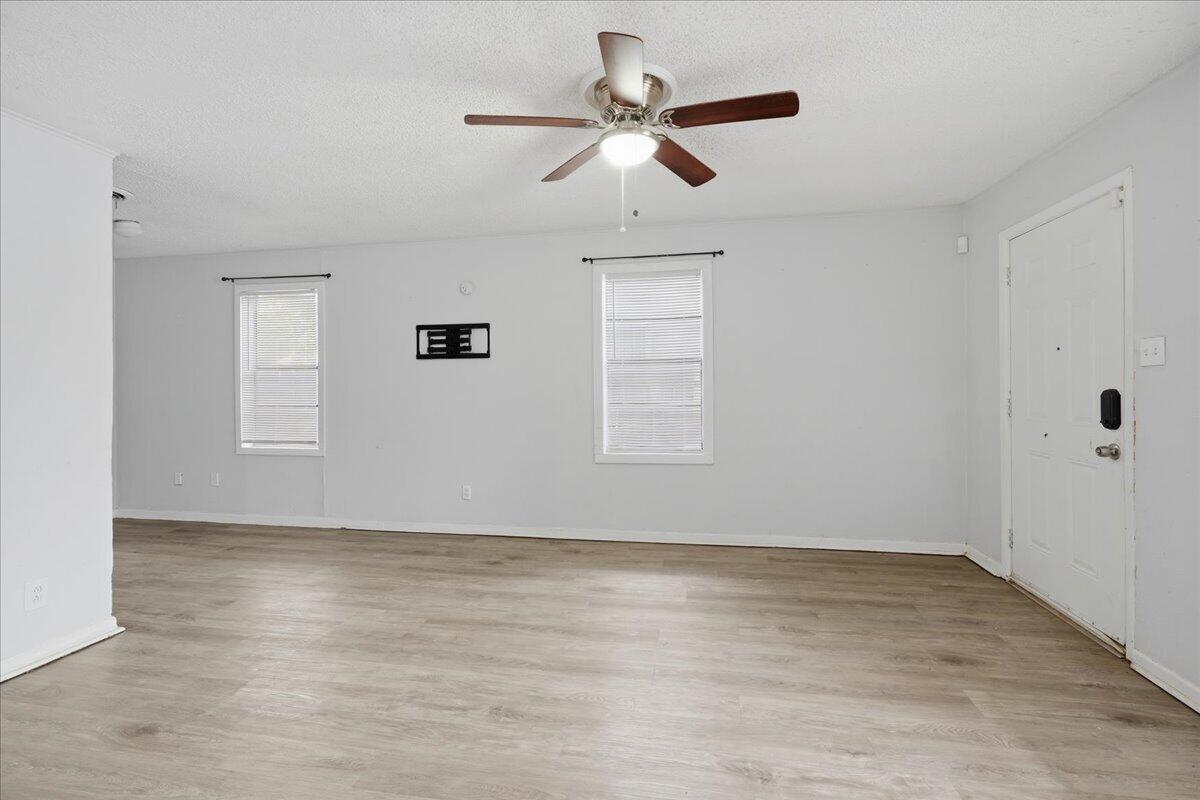 2503 30th Street Lubbock, TX 79410 - Photo 6 of 26 an empty room with wooden floor ceiling fan and windows