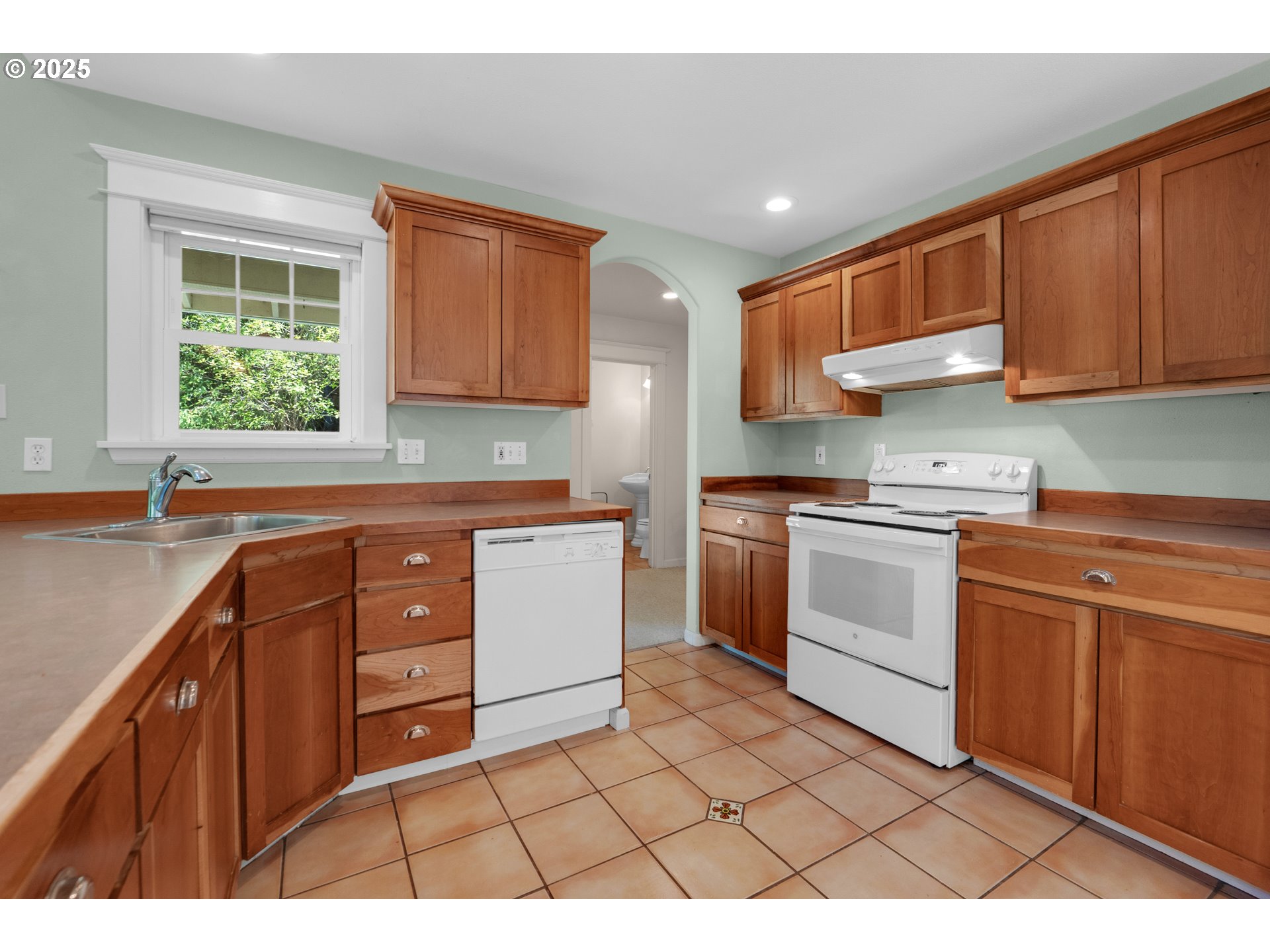 9330 Dewolf Road Nehalem, OR 97131 - Photo 11 of 24 a kitchen with a sink a stove and cabinets