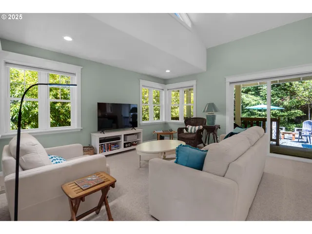 a living room with furniture a large window and a flat screen tv
