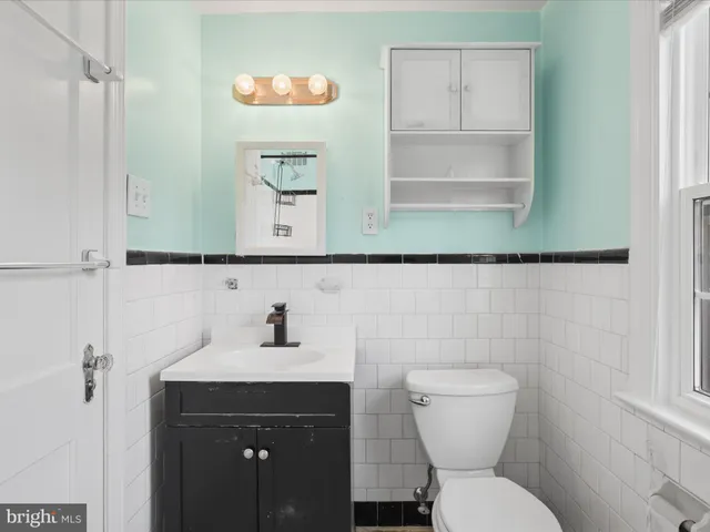 a bathroom with a toilet sink and mirror