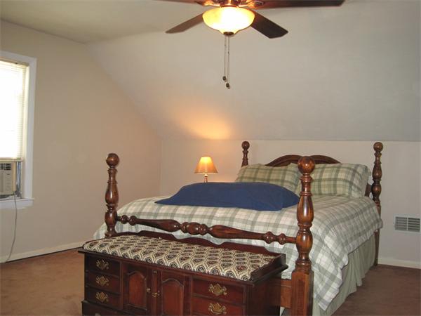 33 Smith Road Sutton, MA 01590 - Photo 12 of 16 a bedroom with a bed and a chandelier