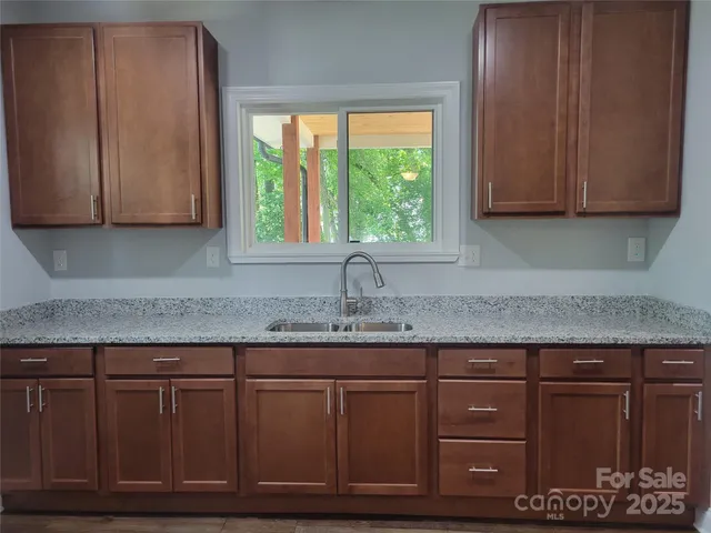 a kitchen with granite countertop cabinets and window