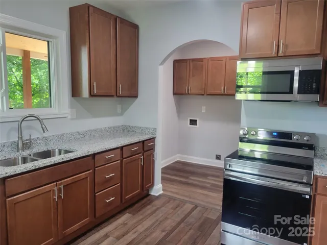a kitchen with sink a microwave and cabinets
