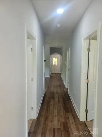 a view of a hallway with wooden floor and closet